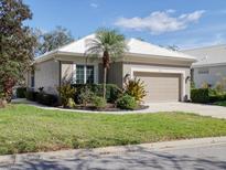 Charming home features an attached garage, manicured lawn, and mature landscaping at 5011 88Th E St, Bradenton, FL 34211