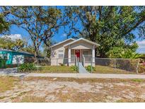 Charming single-story home featuring a red front door and a well-maintained fenced yard at 2634 E 38Th Ave, Tampa, FL 33610