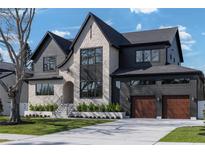 Stunning two-story home featuring a mix of stone and dark siding with a well-manicured front lawn at 1056 Snell Isle Ne Blvd, St Petersburg, FL 33704