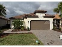 Charming single-story home with tile roof, well-manicured lawn, and two car garage at 11124 Wicker Park Pl, Palmetto, FL 34221