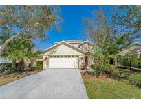 Charming single-Gathering home featuring a two-car garage, well-maintained landscaping, and a welcoming facade at 15107 Searobbin Dr, Lakewood Ranch, FL 34202