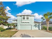 Charming two-story home with a three car garage, tropical landscaping, and a welcoming exterior at 7108 Harvest Glen Ln, Riverview, FL 33578