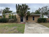 Charming single-story home with a stucco exterior, mature palm trees, and a spacious driveway at 4200 Huntington Ne St, St Petersburg, FL 33703