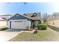 Charming one-story home with attached garage, blue paint and manicured lawn at 9628 Southern Charm Cir, Brooksville, FL 34613