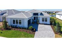 Beautiful single-story home featuring a paver driveway, manicured lawn, and a modern white exterior at 4541 Mondrian Ct, Sarasota, FL 34240