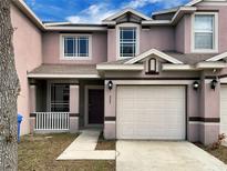 Charming two-story townhome featuring an attached garage and a neatly landscaped front yard with beautiful architectural details at 523 Glenn Cross Dr, Ruskin, FL 33570