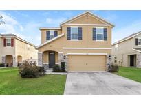 Inviting two-story home showcasing manicured lawn, stone accents, and a two-car garage at 2303 Ashberry Ridge Dr, Plant City, FL 33563