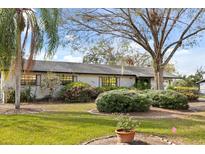 Charming single-story home with lush landscaping and mature trees in a well-maintained yard at 12205 Kelly Ln, Thonotosassa, FL 33592