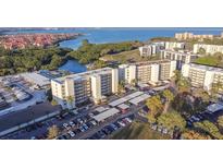 An aerial view showcasing the condo building, parking, and its scenic location near the water at 1000 Cove Cay Dr # 5E, Clearwater, FL 33760