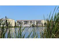 Scenic view of the condo buildings overlooking a serene lake on a clear day at 3672 Lake Bayshore Dr # K327, Bradenton, FL 34205