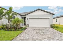 Charming single-Gathering home featuring a paved driveway, two-car garage, and meticulously landscaped front yard at 467 Sun Chaser Dr, Nokomis, FL 34275