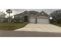 Charming single-Gathering home showcasing a stone facade, a two-car garage, and a well-maintained lawn at 23149 Hammond Ave, Port Charlotte, FL 33954