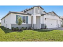 Charming single-Gathering home featuring a manicured lawn, well-maintained landscaping, and an attached two-car garage at 1844 Draughton Dr, Zephyrhills, FL 33541
