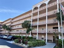 A multi-story residential building with balconies and a well-maintained landscape and parking on a bright day at 5521 80Th Street North # 306, St Petersburg, FL 33709