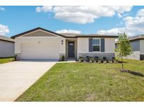 Charming single-story home with well-manicured lawn, attached garage, and welcoming entrance at 31610 Malbec Dr, Brooksville, FL 34602
