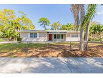 Charming single-story home with a red front door and a well-maintained lawn, located near lush trees at 777 27Th S Ave, St Petersburg, FL 33705