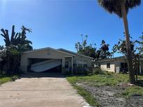 Hurricane damage to home; garage door has failed and debris is scattered in the yard at 1810 New Hampshire Ne Ave, St Petersburg, FL 33703
