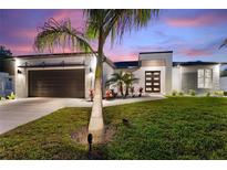 Charming home featuring well-manicured lawn, fresh landscaping and a modern black garage door at 24470 Kingsway Cir, Punta Gorda, FL 33983