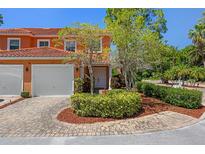Charming two-story villa with red tile roof, brick driveway and lush landscaping at 2353 Max Ct, New Port Richey, FL 34655
