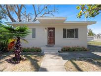 Charming single-story home with a well-maintained lawn, a tidy flower bed, and a quaint front porch at 8608 N 20Th St, Tampa, FL 33604