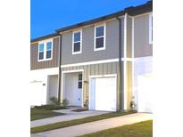 Exterior view of a two-story townhome featuring a gray facade and a one-car garage at 11856 Throttle Pl, Gibsonton, FL 33534