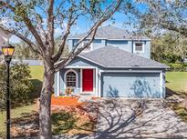 Charming two-story home with a well-manicured lawn, two-car garage, and inviting red front door at 11144 Summer Star Dr, Riverview, FL 33579