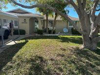 Charming single-story home with well-manicured lawn, mature trees, and covered parking area at 13729 Cox Ave, Hudson, FL 34667