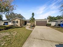 Charming single-story home with a well-manicured lawn and a two-car garage at 1715 Delaware Ne Ave, St Petersburg, FL 33703