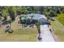 Inviting single Gathering home with palm tree landscaping, attached garage and concrete driveway at 5769 E Price Blvd, North Port, FL 34288