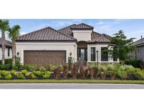 Charming single-story home with a tile roof, two-car garage, and meticulously landscaped front yard at 6237 Plateau Ct, Bradenton, FL 34203