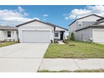 Charming single-story home featuring a two-car garage, well-manicured lawn, and inviting front entrance at 3652 Moscato Dr, Brooksville, FL 34602