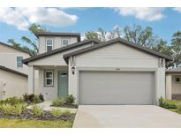 Charming two-story home featuring a two-car garage, well-manicured lawn, and a welcoming light-blue front door at 3824 Radiant Mountain Dr, Plant City, FL 33565