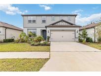 Charming two-story home featuring a two-car garage, landscaped yard, and welcoming front entrance at 12963 Brookside Moss Dr, Riverview, FL 33579