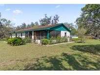 Charming home featuring a screened porch with lush landscaping and a well-maintained yard at 3634 Apfel Rd, Wesley Chapel, FL 33543