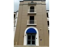 Exterior shot of a multi-story condo building with balconies and a blue awning over the entrance at 8111 Lakewood Main St # 207, Lakewood Ranch, FL 34202