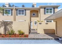 Townhome exterior showcasing a well-manicured facade, including a paver walkway and neat landscaping at 13794 Marseilles Ct, Clearwater, FL 33762