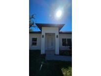 Modern home showcasing a clean, white facade, dark trim and ample natural light at 17065 Malta Ave Ave, Port Charlotte, FL 33954