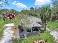 Scenic aerial view of a house with a screened-in porch, a red barn, and green surroundings under a blue sky at 8123 Double Branch Rd # 1, Tampa, FL 33635