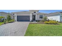 Charming single-story home boasting a well-manicured lawn and a stylish gray brick driveway at 4914 Carova Way, Lakewood Ranch, FL 34211