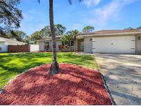 Charming single-story home featuring a manicured lawn and colorful landscaping at 3308 Wind Chime W Dr, Clearwater, FL 33761