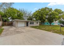 Charming single-story home featuring a spacious front yard, long driveway and attached single car garage at 4129 Highland Loop, New Port Richey, FL 34652