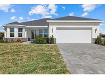 Charming single-story home with a well-manicured lawn and a paved driveway leading to a two-car garage at 7338 N Ficus Tree, Punta Gorda, FL 33955