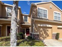 Attractive townhome with tan stucco and stone accents and an attached one car garage at 11805 Castine St, New Port Richey, FL 34654