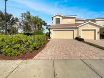 Inviting two-story home featuring an attached two-car garage and meticulously maintained landscaping at 1181 Burgos Dr # 406, Sarasota, FL 34238