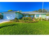 Charming home featuring a well-manicured lawn and colorful garden, creating a welcoming curb appeal at 1430 Newhope Rd, Spring Hill, FL 34606