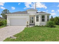 Charming one-story home featuring a two-car garage, landscaped front yard, and neutral color palette at 7443 S Seagrape Rd, Punta Gorda, FL 33955