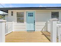 Charming home featuring a light blue front door and a wooden deck for a welcoming entrance at 1805 Rita St, Sarasota, FL 34231
