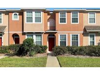 Charming two-story townhouse featuring a well-manicured lawn and vibrant red front door at 8840 Red Beechwood Ct, Riverview, FL 33578