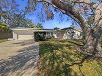 Charming single-story home with a well-maintained lawn and mature trees at 1848 Redcoat Ln, Clearwater, FL 33764