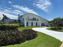 Stunning two-story home featuring a manicured front yard, beautiful landscaping, and a private balcony at 5900 Leeland S St, St Petersburg, FL 33715